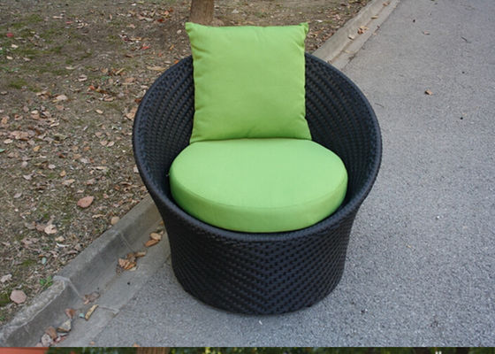 Schwarze runde Rattan-Stühle im Freien, mit grünem Kissen und Kissen